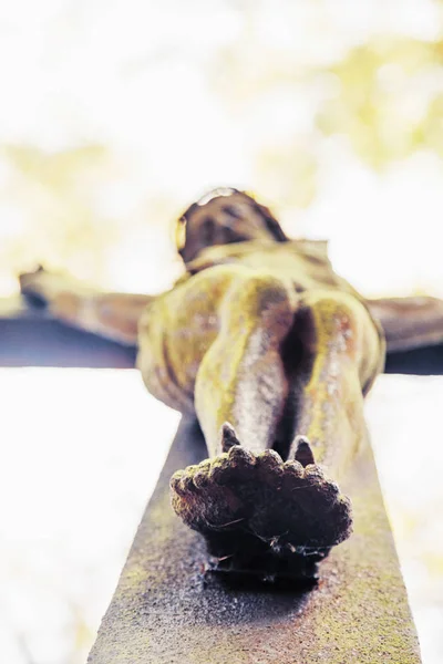 the crucifixion of Jesus Christ as a symbol of God\'s love. Bottom view. Selective focus on the feet.