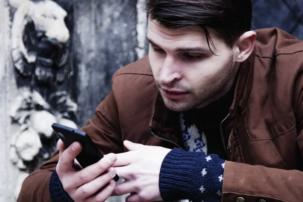 Social Media addiction. young man holding a smartphone(psychological problems, media mania)