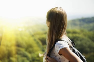 Mutlu genç kadın backpacker sırt çantası konumu dağın zirvesinde olan ve dağların manzarasına sahiptir. (Seyahat, Doğa, macera, zafer kavramı)