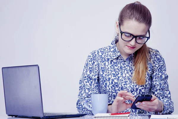 Akıllı telefonlar ve sosyal ağ iş verimlilik gibi en dikkat dağıtıcı. Sms yerine çalışan kadın işçi yazıyor.