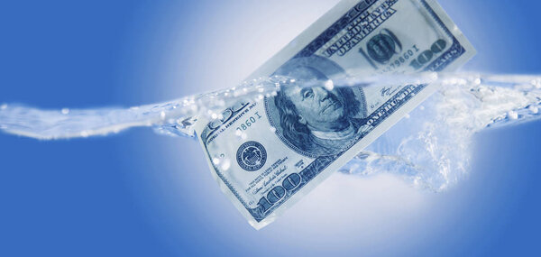 Financial default concept. US Dollar sinking in water as a symbol of global economic crisis