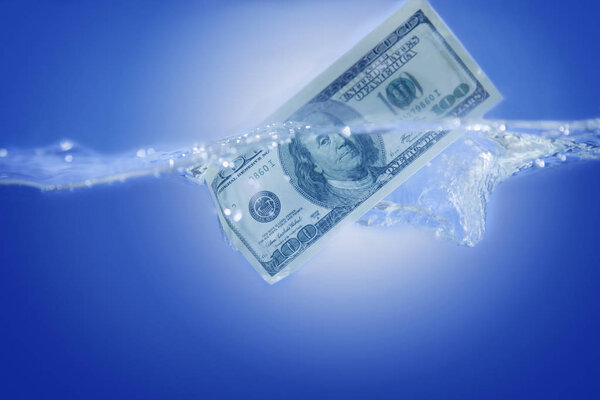 US Dollar sinking in water as symbol of global financiall crisis and uncertain future of international trade and investment. 