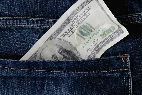 Parçalanmış 100 Amerikan Dolarını kot pantolon cebinde sembol olarak kapat