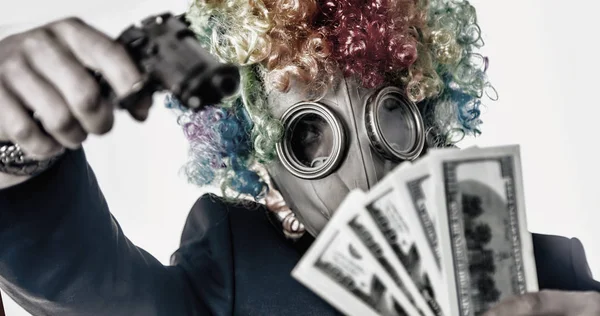 Męski gangster w masce klaun z bronią bierze pieniądze. Szkarłatny — Zdjęcie stockowe