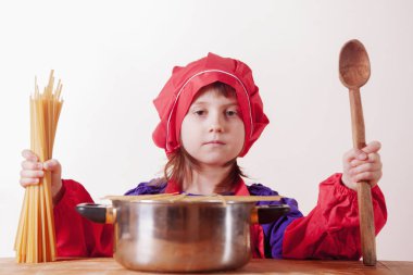 Küçük tatlı kız şef erişteli çorba hazırlıyor. Yiyecek şirketi