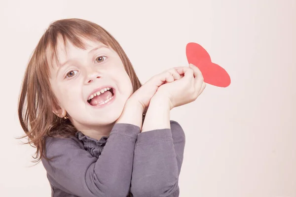 Vtipný portrét roztomilé holčičky drží červené srdce jako syrový — Stock fotografie