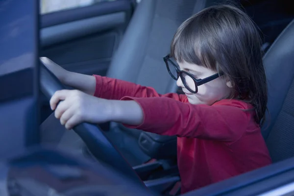 Gevaren en risico 's van minderjarig rijden. Een klein kind meisje drivi — Stockfoto