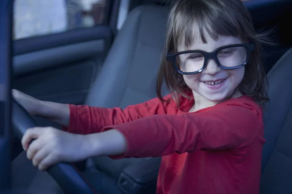 Rijschool. Humoristische foto van gelukkig schattig klein kind meisje le — Stockfoto