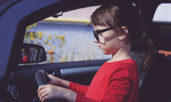 Driving shool. Humorous photo of cute little child girl holds a