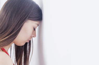 Stresli, güzel bir kadın duvara yaslanıyor. Depresyon, hüsran