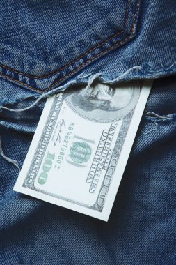 Son parçalanmış 100 Amerikan Doları kotun cebi yırtılmış.