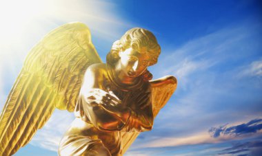 Mavi gökyüzüne karşı altın melek. Din, inanç, sonsuzluk kavramı.