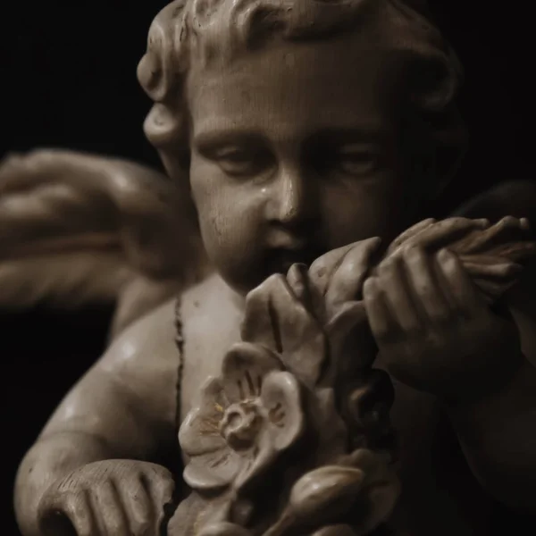 Anjo de mármore com flores. Estátua antiga. — Fotografia de Stock