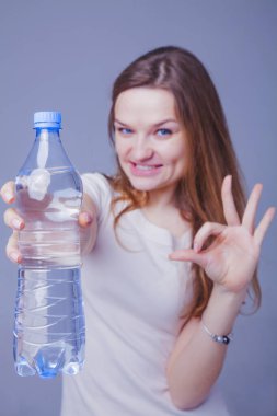 Elinde saf su şişesi tutan genç ve güzel bir kadın. Taze Dr.