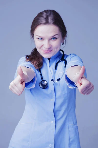 Portrét šťastné mladé doktorky ukazující gesto ukazující prsty nahoru — Stock fotografie