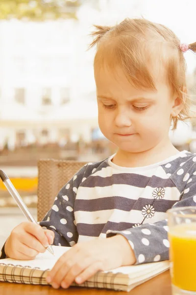 Mała dziewczynka biznesu pisze w notatniku i planowania jej w — Zdjęcie stockowe