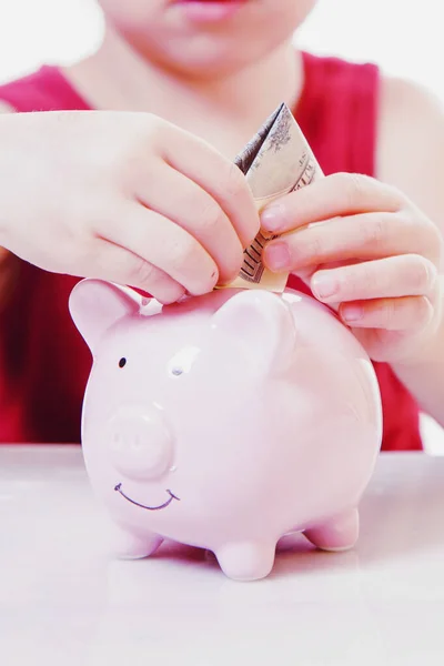 Seving money at the bank concept. Close up little child girl ins
