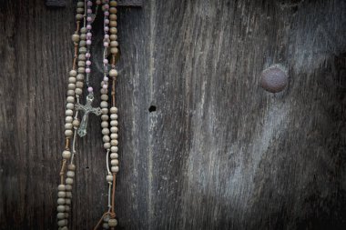 Eski tespih, eski ahşap arka plana karşı kurtuluşun ve insan ruhunun sonsuz hayatının sembolü olarak.