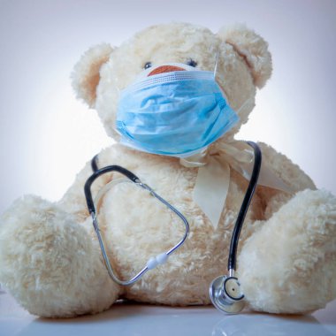 Coronavirus ve Hava kirliliği pm2.5 konsepti. Oyuncak ayı koruyucu yüz maskesi ve steteskopla. 