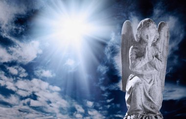 Antik melek heykeli ışık huzmeleriyle gökyüzüne karşı bulutlarla
