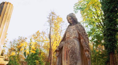 Depresyon, acı ve kederin sembolü olarak mezardaki kadın heykeli. İnanç, din ve ölüm kavramı. Yüze seçici odaklanma.