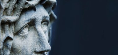 Dikenli İsa 'nın gözlerinden çarpıcı bir manzara. Eski bir taş heykel parçası koyu arkaplana karşı.