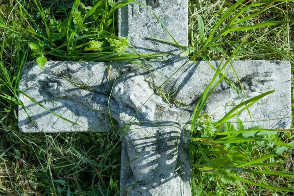 耶稣基督被钉在十字架上古老的石头摧毁了青草中的雕像 — 图库照片