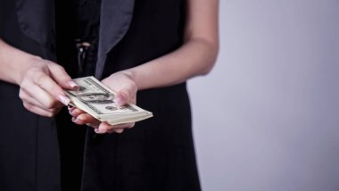 Yakın plan iş kadını Amerikan doları paralarını sayıyor. Gelir, kâr, muhasebe kavramı.