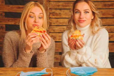 Hava kirliliği pm2.5 ve koronavirüs salgını sırasında gıda teslimatı güvenliği. Genç güzel kadınlar ilaç maskesi takmadan pizza yiyorlar.. 