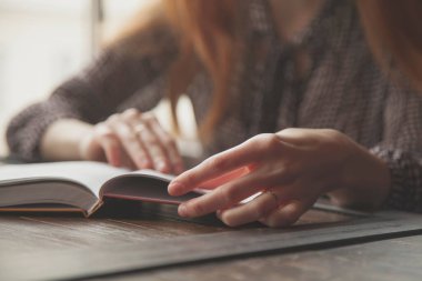 Kapalı alanda kitap okuyan genç bir kadın. Rahatla, eğitim, kendini geliştirme konsepti.