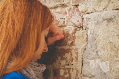 Üzgün kadın umutsuzluk, depresyon ve hüsranın sembolü olarak duvara yaslanıyor..