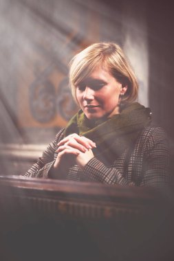 Kiliselerde dua eden sarışın güzel bir kadının geçmişe dönük tasviri. Din, inanç, meditasyon konsepti.