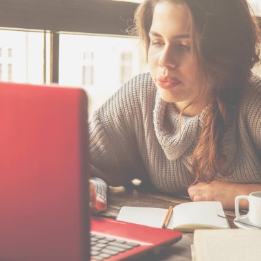 Kafede dizüstü bilgisayarla çalışan güzel bir kadın serbest yazar.. 