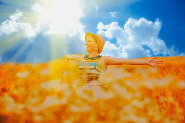 太陽の光の中で劇的な空の背景に対して小麦畑の美しいブロンドの女性の肖像画 夏休みのコンセプト — ストック写真