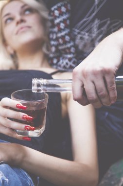 Parkta oturup içki içen bir çift. Sarhoş genç insanlar. Ailede alkolizm, bağımlılık sorunu, depresyon kavramı.