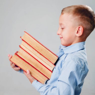 Öz gelişimin ve amacının sembolü olarak kitap yığınıyla okul çağındaki genç bir çocuk.. 