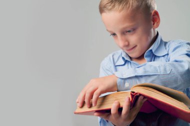 Başarının ve kişisel gelişimin sembolü olarak kitap okuyan küçük bir çocuk. Yatay resim.