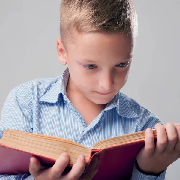 Close up little boy reading book as symbol of motivation to success and self development.