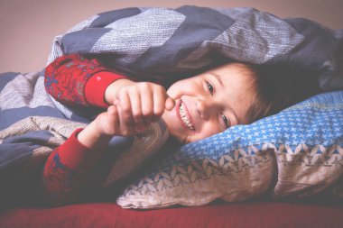 - Henüz uyumak istemiyorum. - Neden? Yatakta eğlenen ve uykuya dalmak istemeyen sevimli, aktif, küçük bir kız. Yatay resim.