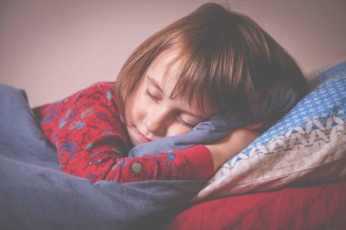 Uyku zamanı konsepti. Küçük tatlı bir kızın mutlu rüyaları. Yatakta dinleniyor.. 