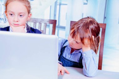 Yorgun ve bitkin iki genç iş kızının komik fotoğrafı. Çalışan, iletişim kuran ve online görüşme yapan iki genç kız..