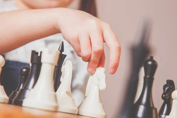 Investing in the future: training and education of the future chess champion. Close up young girl learns to play chess. Development, childhood, success, wunderkind concept