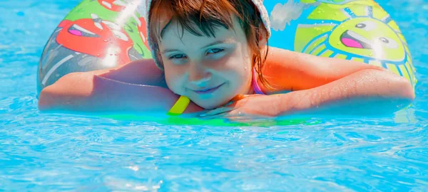 年轻而快乐的小女孩在游泳池里挥洒着水 享受着快乐的休闲活动 横向图像 — 图库照片