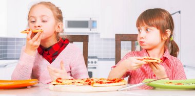 Pizza teslimatı bedava. En iyi yiyeceklerin sembolü olarak ellerinde pizza dilimleri olan küçük şirin kızların portresi. Yatay resim.