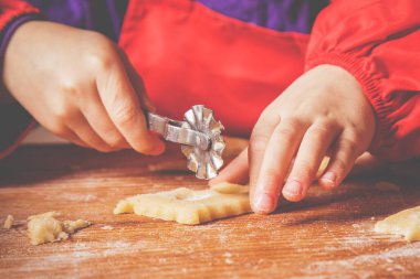 Şirin küçük kız şefin ahşap masada un ile kek hamuru pişirmesi..