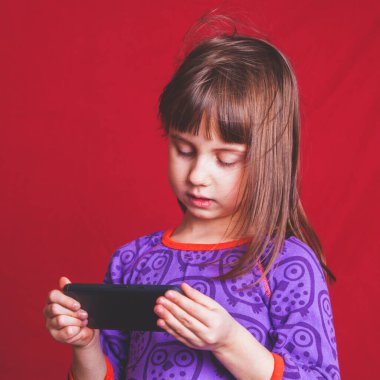 Beğenilere bağımlı küçük bir kızın psikolojik görüntüsü. Cep telefonlu gergin bir çocuğun portresi. Duygusal ve socail ağ bağımlılığı konsepti. 