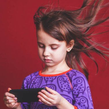 Sevgi düşkünü şirin bir kızın psikolojik görüntüsü sosyal ağlar onun muhtaçlığını besliyor. Cep telefonlu gergin bir çocuğun portresi. Olumsuz duygu ve duygusal bağımlılık kavramı. 