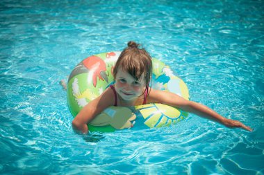 Yüzme havuzunda oldukça mutlu küçük bir kızın portresi. Dışarıda oynayan komik çocuk. Yaz tatili kavramı. Yatay resim.