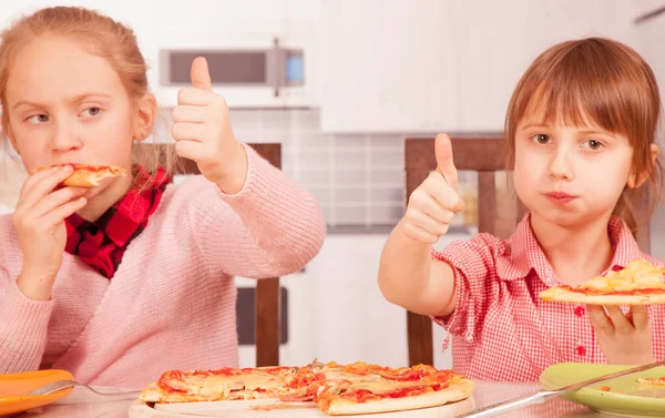 I love pizza! Cute little child girl eating pizza and making Ok gesture. Selective focus on fingers. Horizontal image.