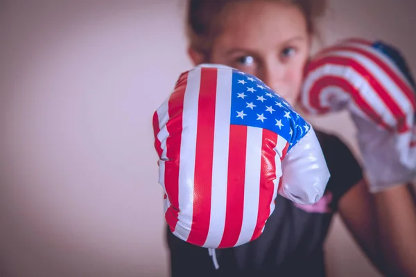 stock image Sport and boxing concept. Portrait of young cute girl fighter with boxing gloves in flag of USA.